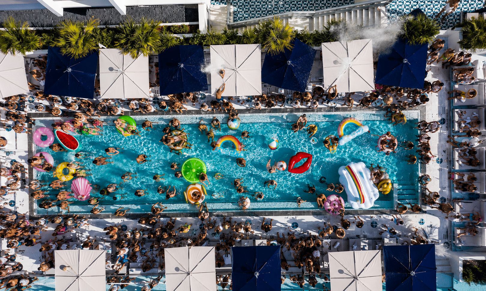 Aerial view of Moxy Pool Party Miami with colorful floats and packed crowd